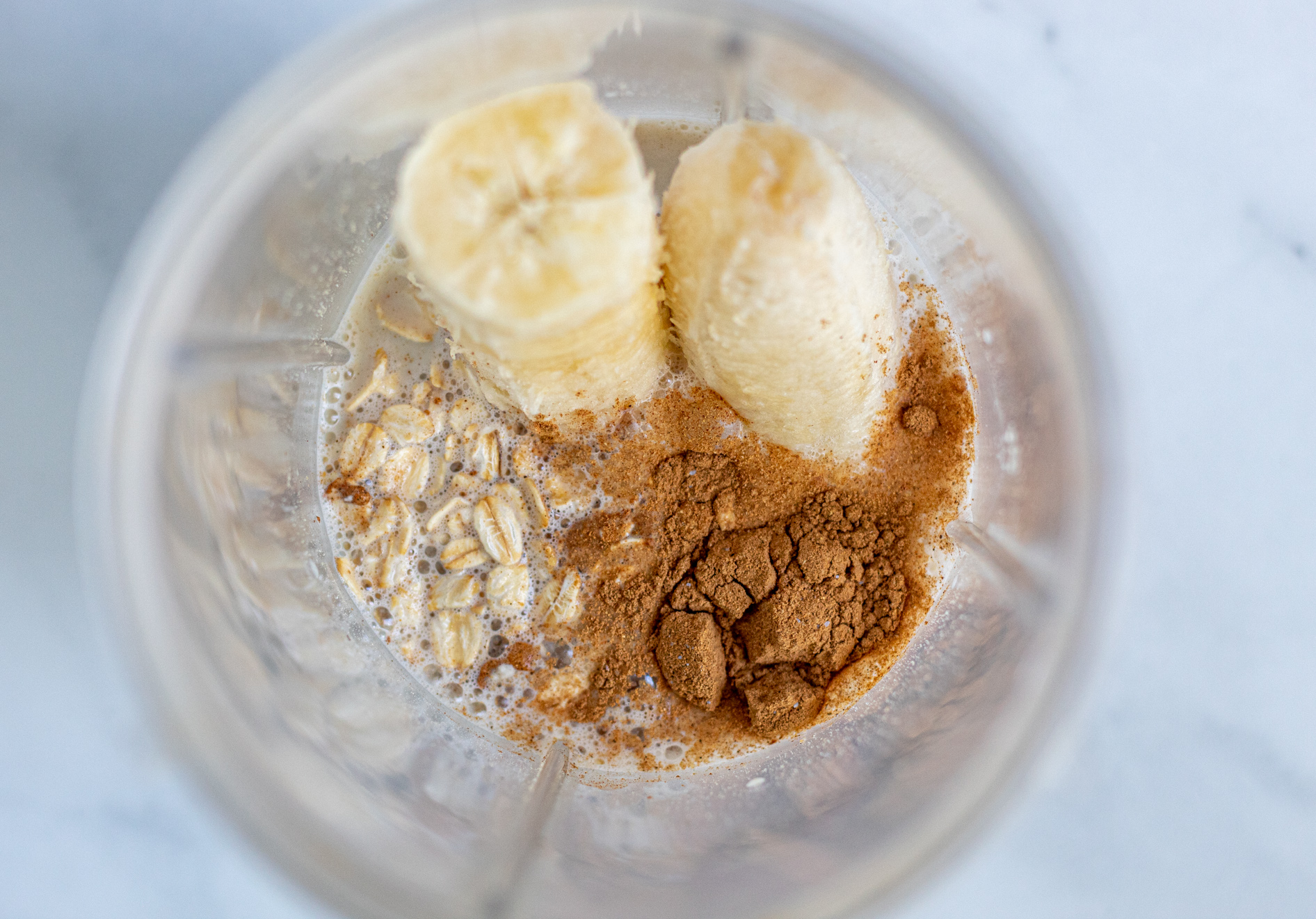 Banana, oats, cinnamon, milk, pancake ingredients in a blender.