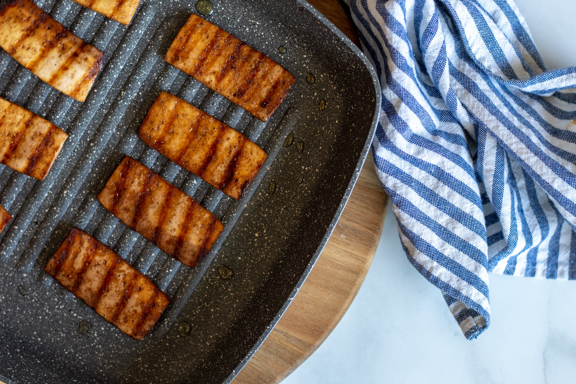 Tofu bacon with custom vegan marinade on a skillet.