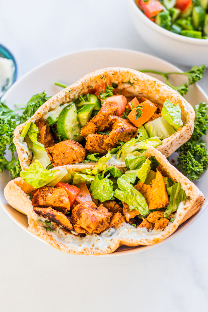 Vegan Chicken Shawarma with spices, pita pocket, flatbread, parsley, cucumber, garlic sauce, hummus