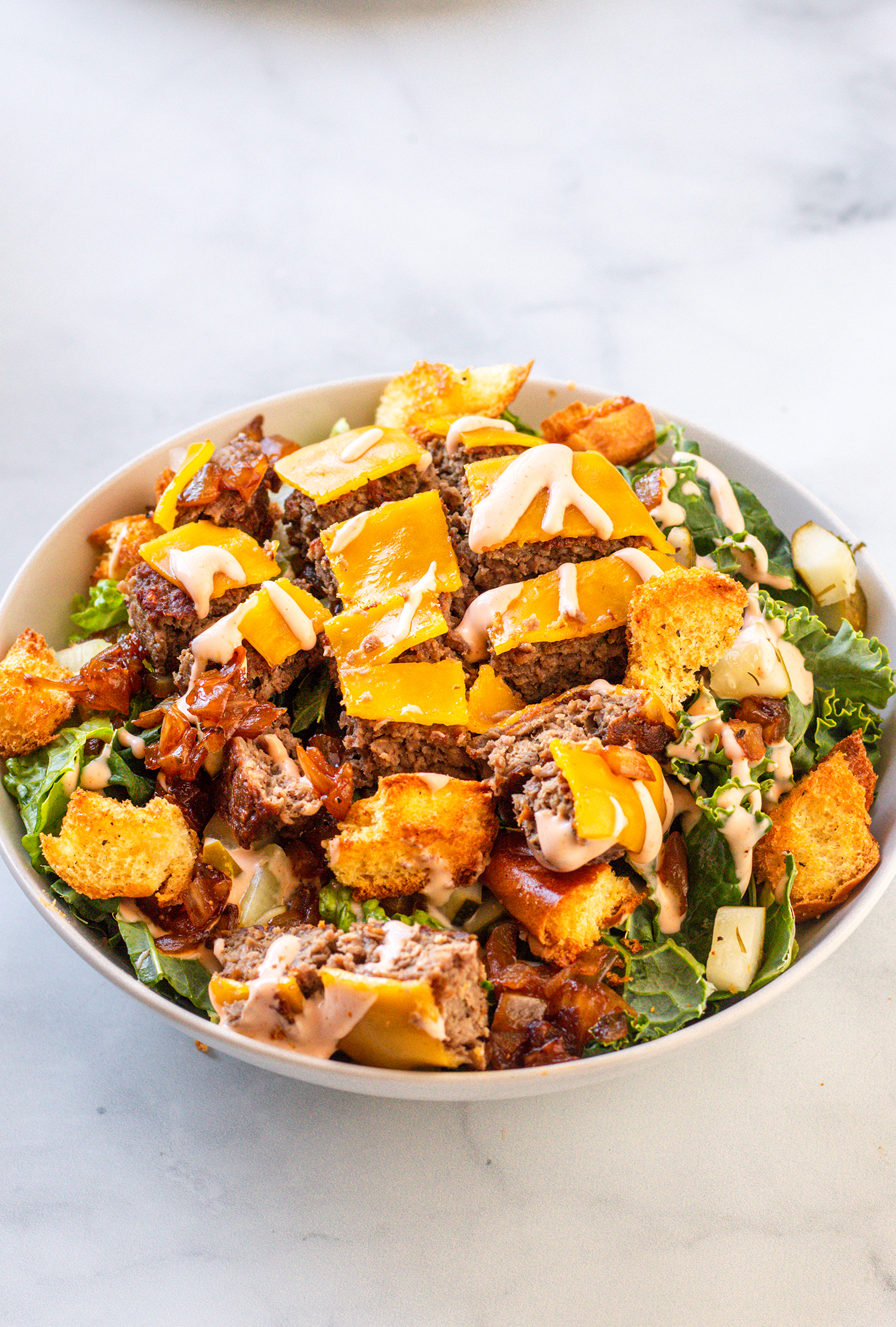 Vegan in-n-out cheeseburger salad with grilled onions thousand island dressing and croutons