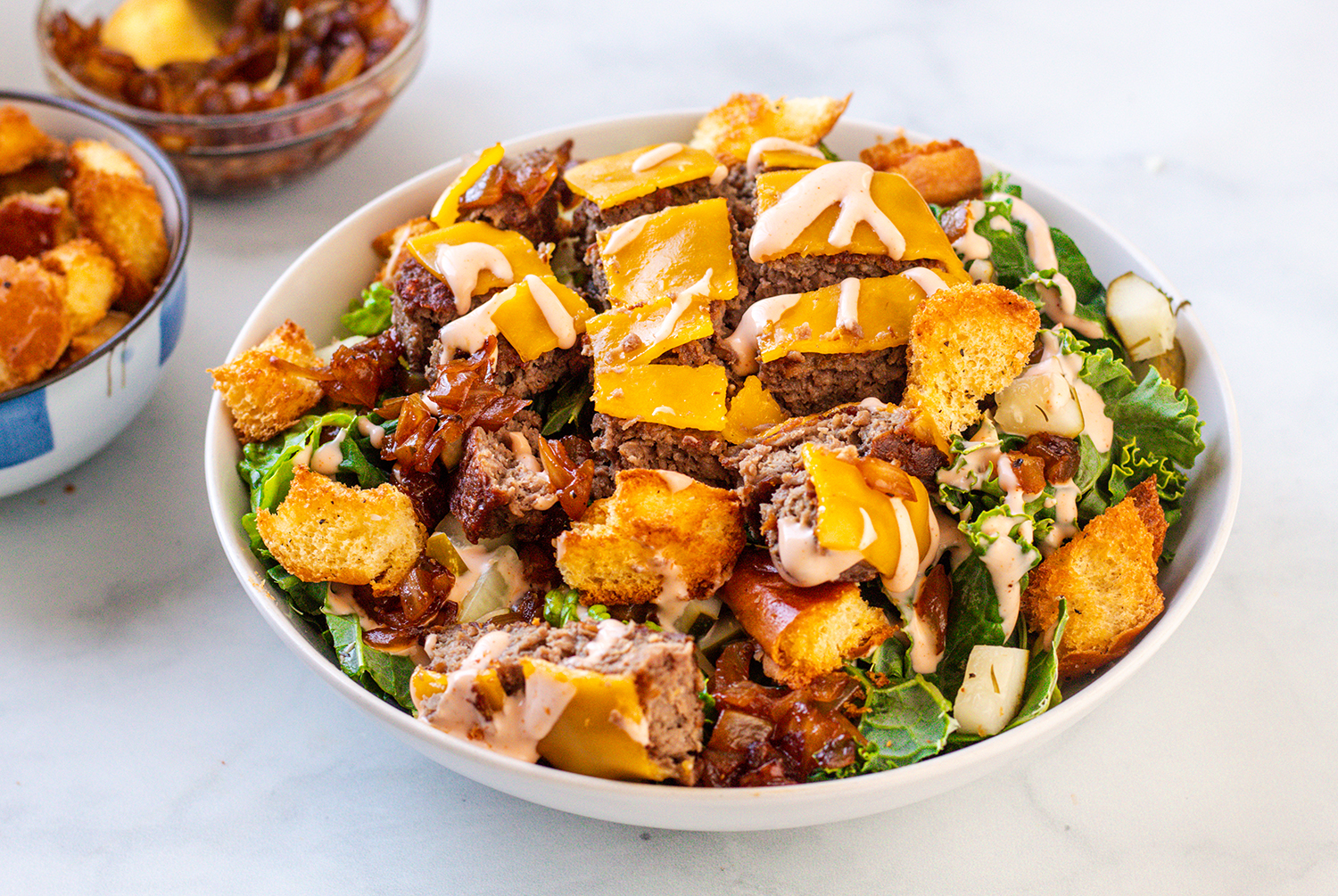 Vegan in-n-out cheeseburger salad with grilled onions thousand island dressing and croutons