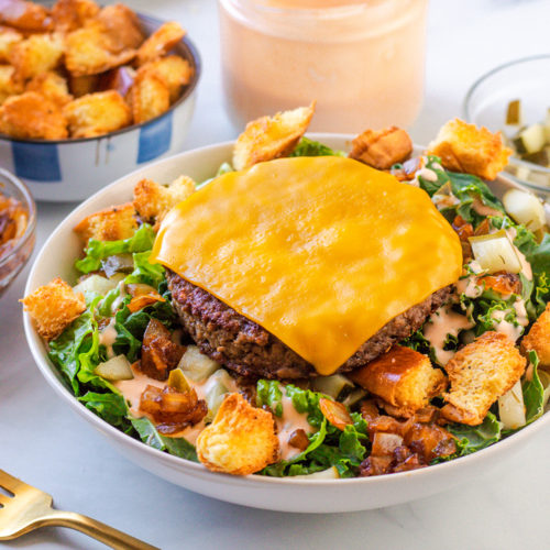 Vegan in-n-out cheeseburger salad with grilled onions thousand island dressing and croutons